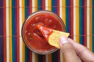 nachos doppar i en chili såser foto