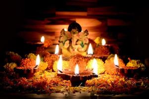 lera diya lampor tända med lord ganesha under diwali firande. gratulationskort design indisk hindu ljus festival kallas diwali foto