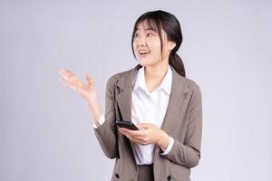 ung asiatisk affärskvinna som använder telefonen på vit bakgrund foto