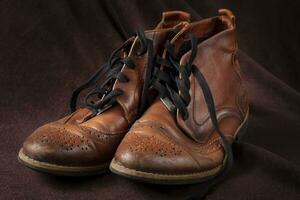gammal läder brun skor på en mörk bakgrund. foto