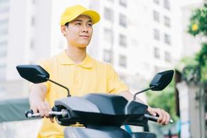 asiatisk leveransperson kör sin motorcykel för att leverera till kunden foto