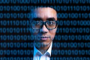 porträtt av asiatisk affärsman med rader med kod i ansiktet. begreppet människan digitaliseras i framtiden