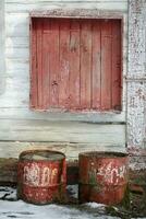 bakgrund gammal och övergiven. trä- vägg med peeling måla och rostig fat. foto