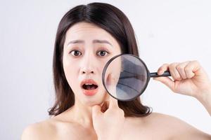 asiatisk kvinna med ett förvånat uttryck när hon uppträder akne