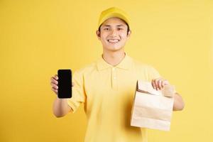 porträtt av manliga leverantör håller shopping väska och telefon