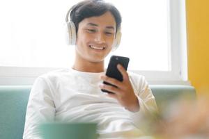 asiatisk man sitter och njuter av musik