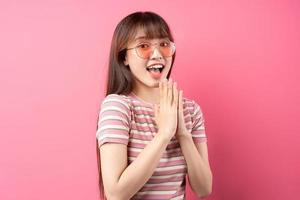 bild av ung asiatisk tjej som bär rosa t-shirt på rosa bakgrund foto