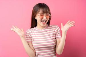bild av ung asiatisk tjej som bär rosa t-shirt på rosa bakgrund foto