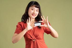 asiatisk kvinna håller bankkort