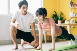 asiatisk pojkvän instruerar sin flickvän att träna hemma