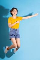 ung asiatisk flicka som poserar på blå bakgrund
