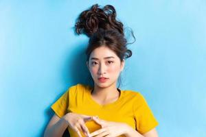 porträtt av ung asiatisk kvinna på blå bakgrund foto