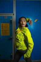 ett asiatisk man i en grön jacka är Framställ i främre av en blå dörr foto