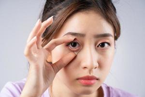 den unga asiatiska kvinnan öppnade ögonen med handen