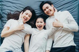 lyckligt asiatiskt familjeporträtt med mor, far och dotter foto