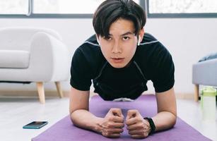 ung asiatisk man som tränar hemma foto