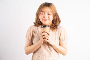ung asiatisk flicka som håller kaffekoppen med uttryck på bakgrunden foto