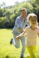 far jagar sin lilla dotter medan han leker i parken foto