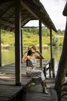 avkopplande ung kvinna på träbrygga vid sjön foto