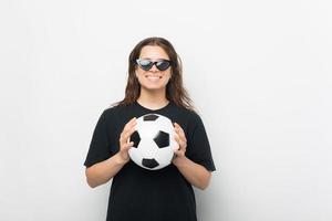 foto av den glada unga kvinnan som bär solglasögon och håller fotboll