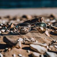 en par av solglasögon Sammanträde på topp av en sandig strand foto