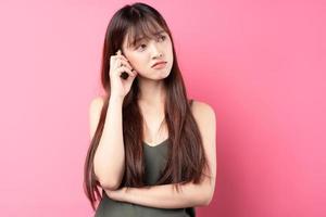 ung asiatisk flicka som poserar på en rosa bakgrund