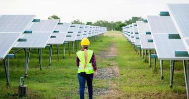 en ung kvinnlig solcellstekniker arbetar hårt. arbetar med alternativ energi solenergi foto
