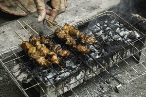 topp se av sate eller satay, traditionell mat från indonesien är varelse grillad på eldig träkol. foto