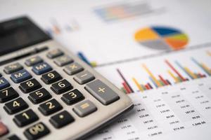 miniräknare på diagram- och diagrampapper. ekonomi, konto, statistik, analytisk forskningsdata och affärsföretagets möteskoncept foto