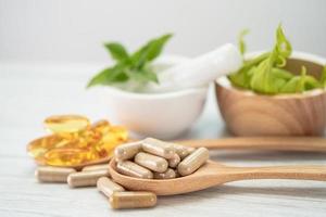 alternativ medicin ört organisk kapsel med vitamin e omega 3 fiskolja, mineral, läkemedel med örter blad naturliga kosttillskott för ett hälsosamt gott liv. foto