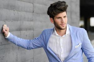 attraktiv ung stilig man, modell av mode i urban bakgrund foto