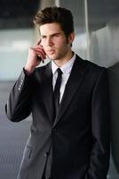 attraktiv ung affärsman i telefon i en kontorsbyggnad foto