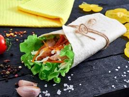 tortilla wrap sandwich med kött och vägetables på trä