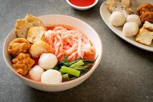 små platta risnudlar med fiskbollar och räkor i rosa soppa, yen ta fyra eller yen ta fo - asiatisk matstil foto
