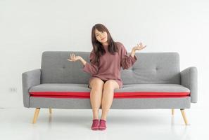 asiatisk kvinna på soffan i vardagsrummet med kopieringsutrymme foto