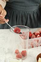 förberedelse framställning jordgubb juice eller slushy med frysta jordgubb foto