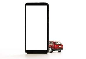 röd leksaksbil och smartphone isolerad på vitt foto