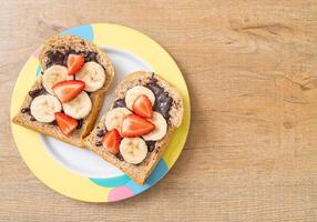 helvete bröd rostat med färsk banan, jordgubbe och choklad till frukost foto