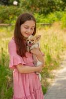 chihuahua hund i armarna på en ung flicka. en tonåring med en valp. foto