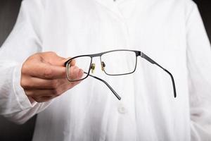 optiker läkare ger glasögon till en patient för att förbättra synen