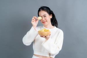 ung asiatisk kvinna äter potatischips foto
