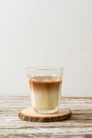 glas lattekaffe, kaffe med mjölk på trä bakgrund foto