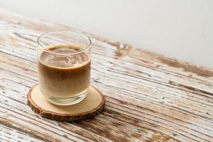 glas lattekaffe, kaffe med mjölk på trä bakgrund foto