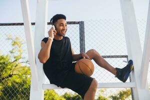 svart man håller på med sporter, spelar basketboll på soluppgång, aktiva livsstil, solig sommar morgon- foto