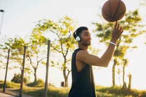 svart man håller på med sporter, spelar basketboll på soluppgång, aktiva livsstil, solig sommar morgon- foto