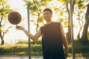 svart man håller på med sporter, spelar basketboll på soluppgång, aktiva livsstil, solig sommar morgon- foto