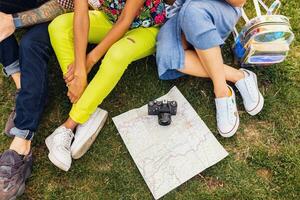 Lycklig ung företag av talande leende vänner Sammanträde parkera foto