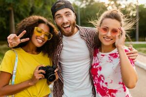 Lycklig ung företag av emotionell leende vänner gående i parkera foto