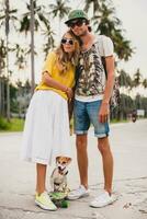 ung eleganta hipster par i kärlek på semester med hund och skateboard, foto