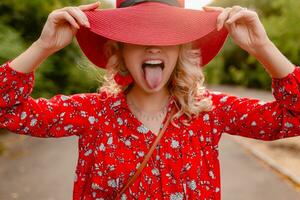 attraktiv eleganta blond leende kvinna i sugrör röd hatt och blus sommar mode foto